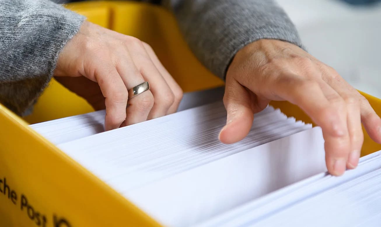 Kuvertierte Werbebriefe werden für den Versand als Dialogpost in Postkisten sortiert